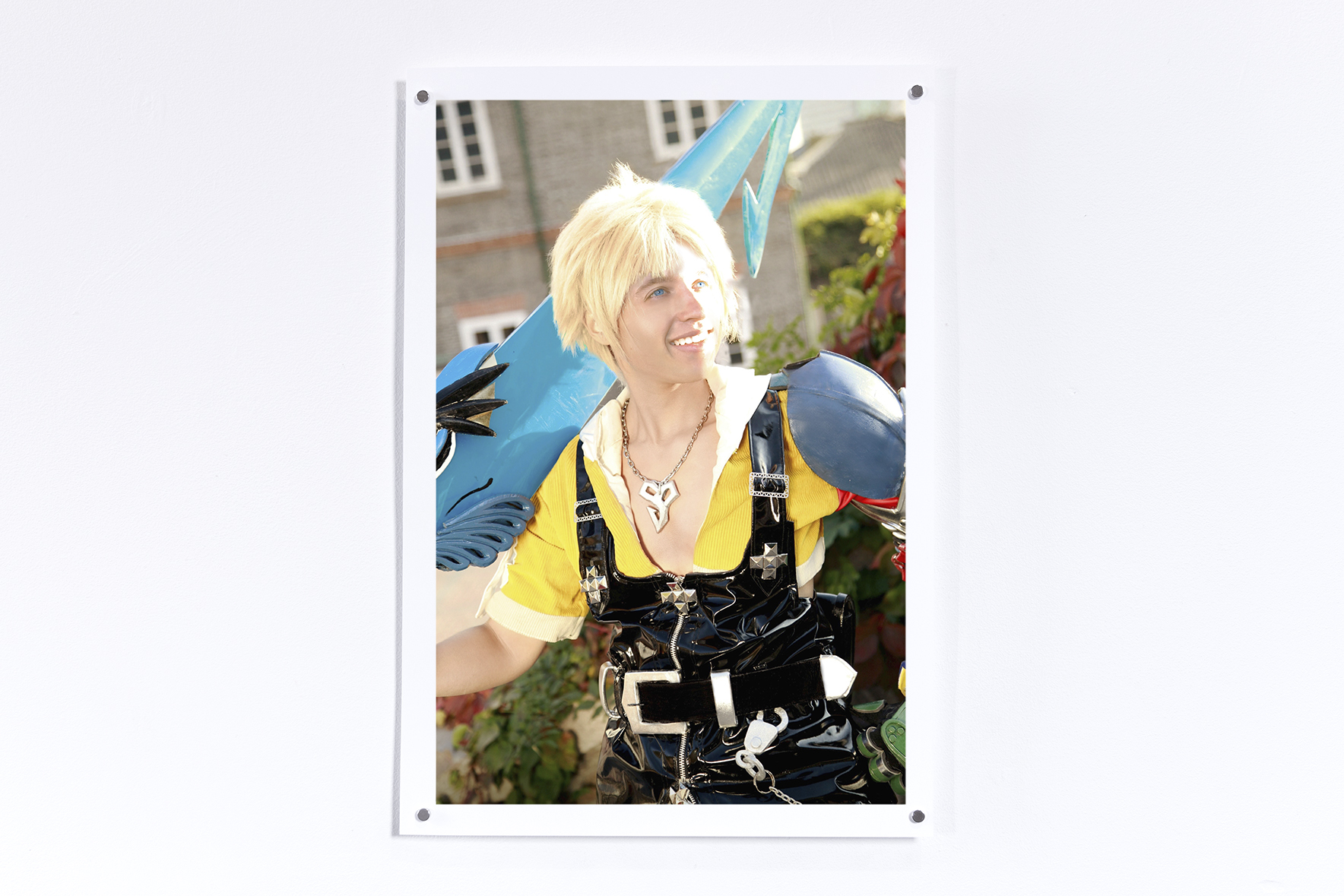 Print hung on a white wall of Tidus from Final Fantasy 10 smiling with a sword with Jesse's face superimposed on the character
